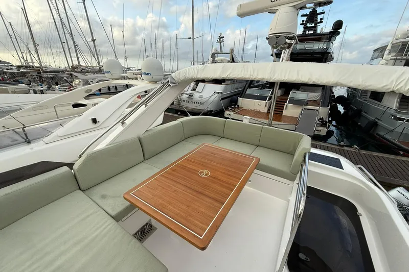 Gbtt Ex Lennartz Yacht Photos Pics Luxurious 2025 Nimbus 495 Flybridge yacht with elegant seating and wooden table in marina.