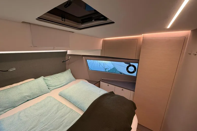 Gbtt Ex Lennartz Yacht Photos Pics Luxurious interior cabin of 2025 Nimbus 495 Flybridge yacht with modern bedding and lighting.