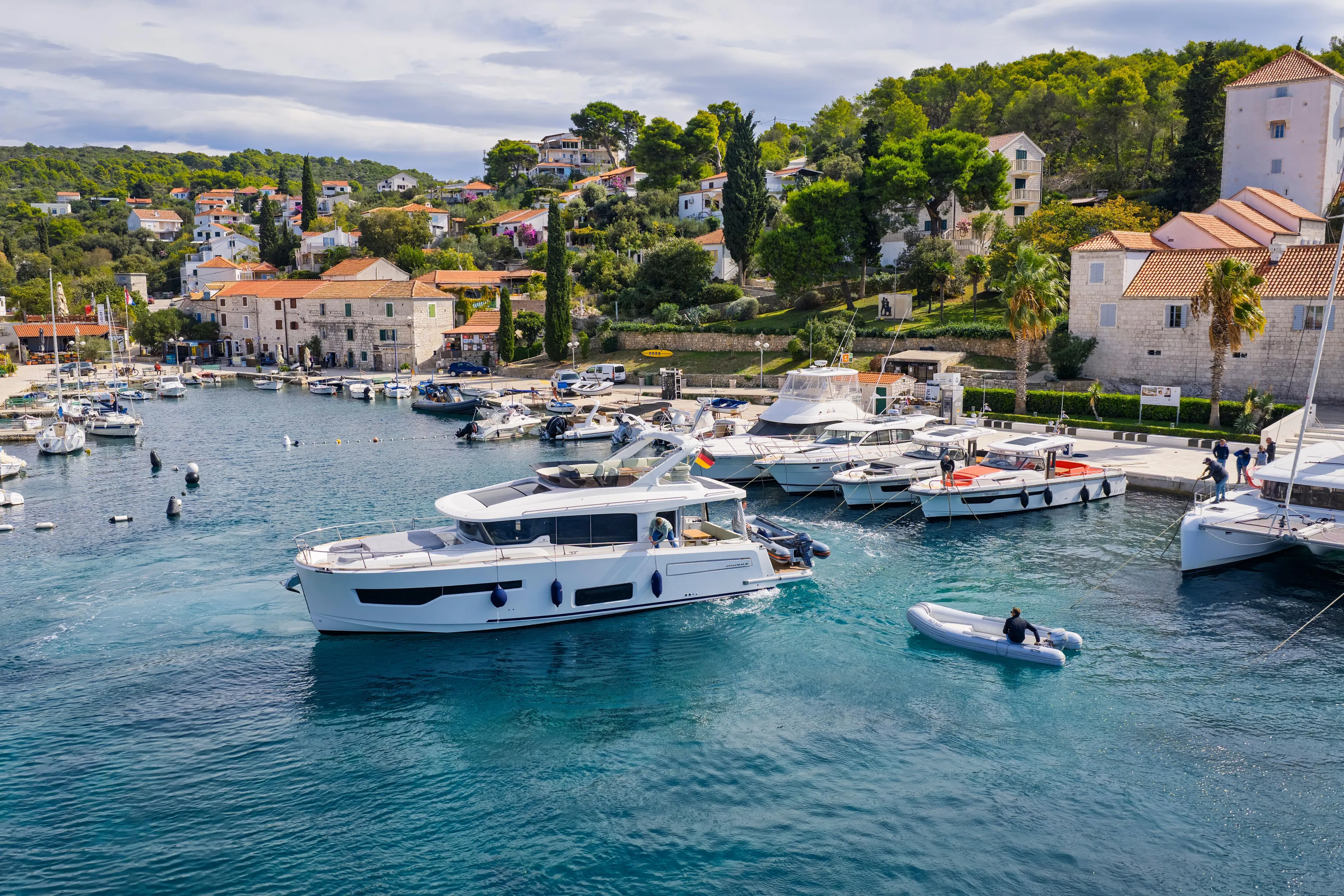 Gbtt Ex Lennartz Yacht Photos Pics 2025 Nimbus 495 Flybridge yacht in scenic marina with lush hillside backdrop.