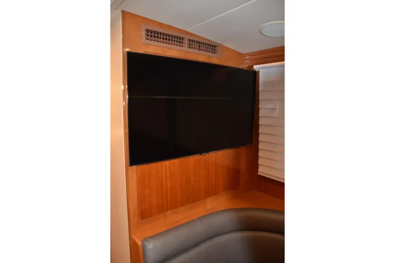 Steel Dreamin Yacht Photos Pics Flat-screen TV in 2001 Hatteras 55 Convertible yacht interior with wood paneling.