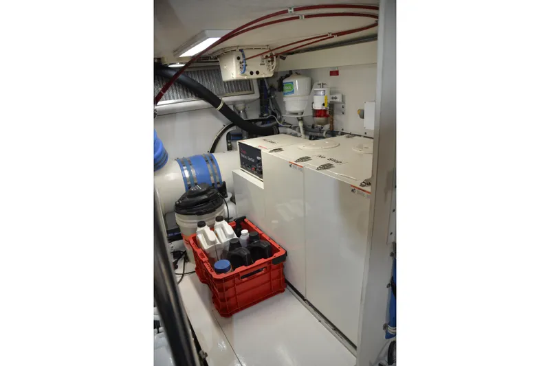 Steel Dreamin Yacht Photos Pics Engine room of 2001 Hatteras 55 Convertible yacht with equipment and maintenance supplies.