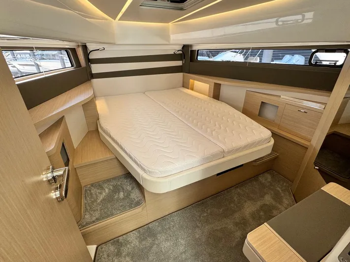  Yacht Photos Pics Luxurious cabin interior of 2025 Jeanneau DB/37 IB yacht with modern design and cozy bed.