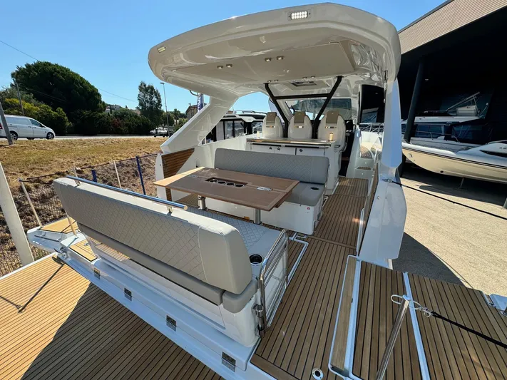  Yacht Photos Pics 2025 Jeanneau DB/37 IB luxury yacht interior with seating and table, docked outdoors.