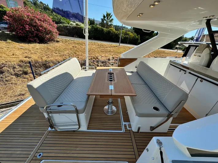  Yacht Photos Pics 2025 Jeanneau DB/37 IB yacht interior with elegant seating and wooden table.