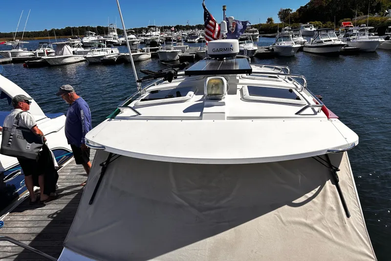  Yacht Photos Pics 2014 Cutwater C-28 boat docked, with people conversing nearby, surrounded by other boats.