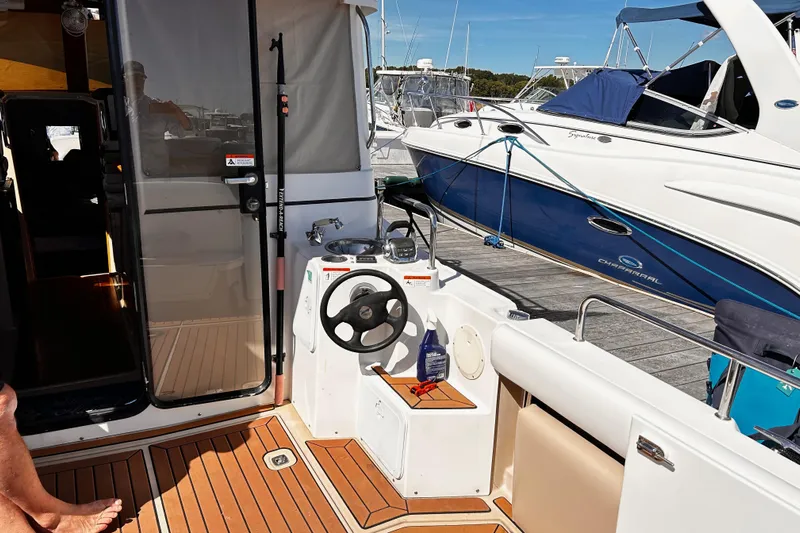  Yacht Photos Pics 2014 Cutwater C-28 boat interior with helm, docked beside another vessel.