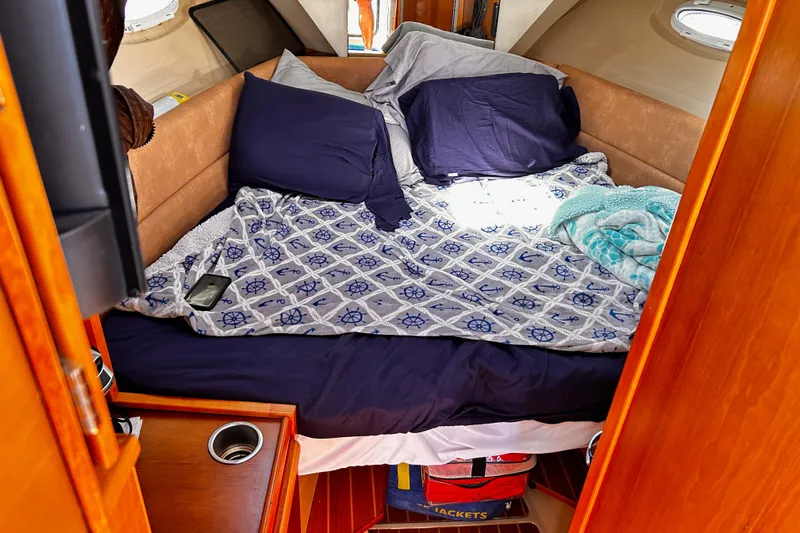  Yacht Photos Pics Cozy cabin interior of 2014 Cutwater C-28 boat with nautical-themed bedding.