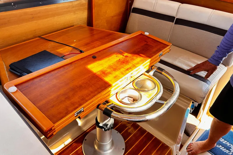  Yacht Photos Pics 2014 Cutwater C-28 interior with wooden table, cup holders, and cushioned seating.