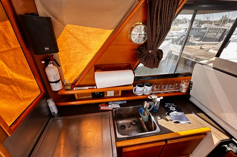  Yacht Photos Pics 2014 Cutwater C-28 boat interior with kitchen sink, clock, and window view of marina.