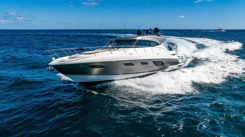 El Mar V Yacht Photos Pics 2022 Riviera 6000SY yacht cruising on open ocean under clear blue sky.