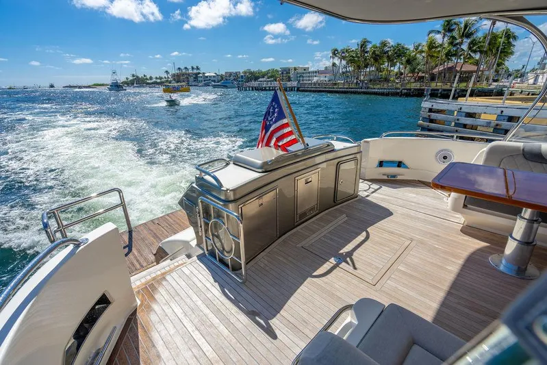 El Mar V Yacht Photos Pics Luxurious 2022 Riviera 6000SY yacht deck with ocean view and American flag.