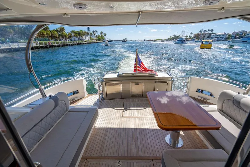 El Mar V Yacht Photos Pics Riviera 6000SY 2022 yacht interior with ocean view, featuring seating and table.