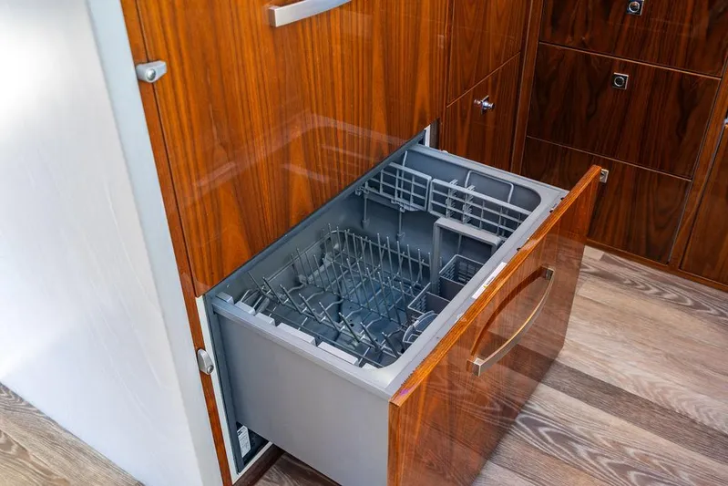 El Mar V Yacht Photos Pics Open dishwasher drawer in 2022 Riviera 6000SY yacht kitchen with wooden cabinetry.
