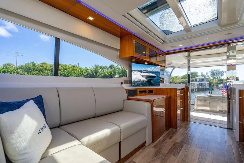 El Mar V Yacht Photos Pics Luxurious interior of 2022 Riviera 6000SY yacht with modern furnishings and scenic view.