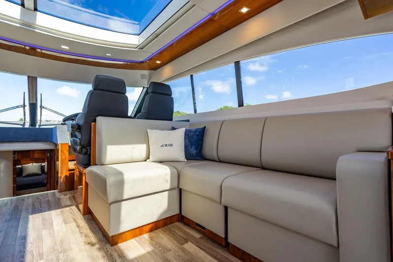 El Mar V Yacht Photos Pics Luxurious interior of 2022 Riviera 6000SY yacht with plush seating and panoramic windows.