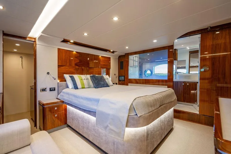 El Mar V Yacht Photos Pics Luxurious bedroom interior of 2022 Riviera 6000SY yacht with modern design and elegant wood finishes.