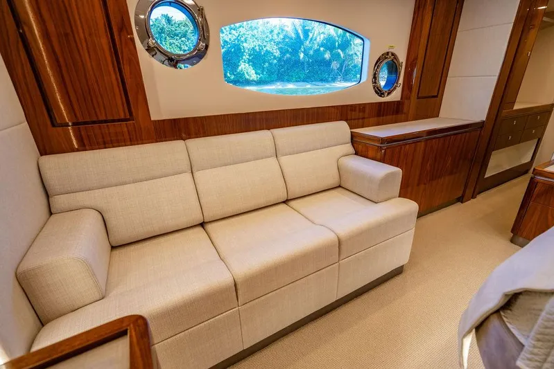 El Mar V Yacht Photos Pics Luxurious interior of 2022 Riviera 6000SY yacht with beige sofa and wooden accents.