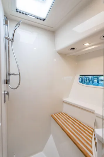 El Mar V Yacht Photos Pics 2022 Riviera 6000SY yacht shower with sleek design and wooden bench.