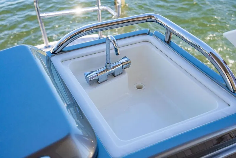 El Mar V Yacht Photos Pics Luxury yacht sink on 2022 Riviera 6000SY, featuring sleek chrome faucet and ocean backdrop.