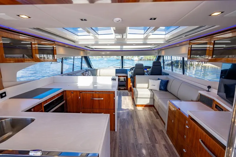 El Mar V Yacht Photos Pics Luxurious interior of 2022 Riviera 6000SY yacht with modern kitchen and seating area.