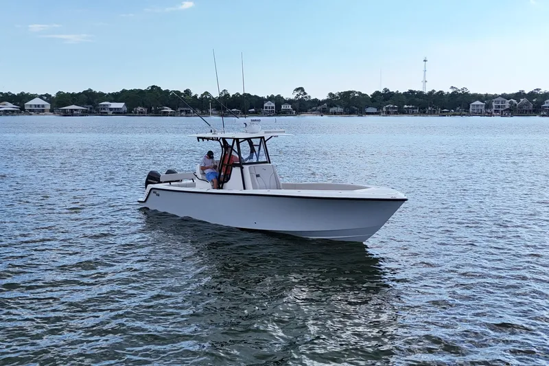  Yacht Photos Pics 2023 SeaVee 32 boat on calm water near shoreline houses.
