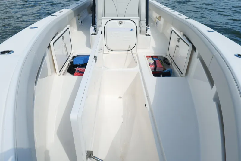 Yacht Photos Pics 2023 SeaVee 32 boat interior with open storage compartments on calm water.