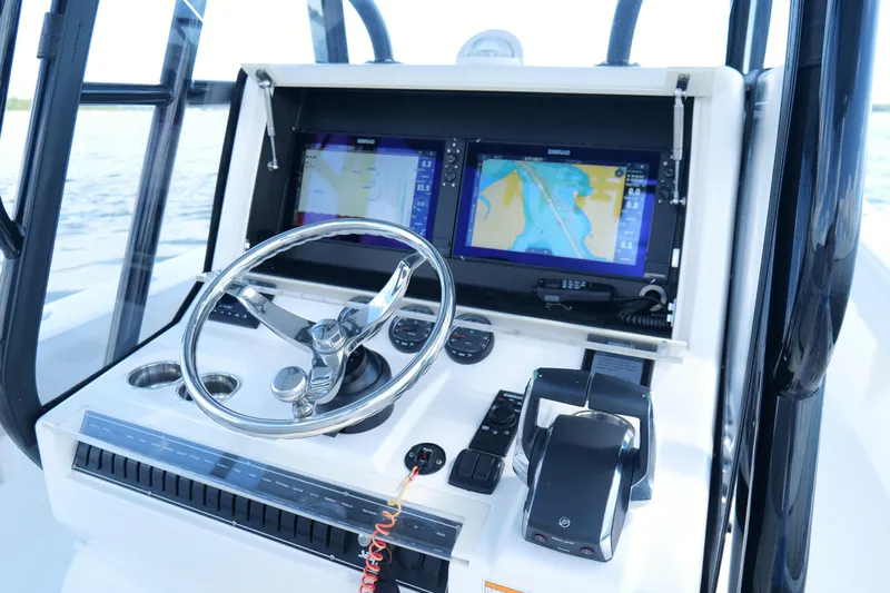  Yacht Photos Pics 2023 SeaVee 32 boat dashboard with navigation screens and steering wheel.
