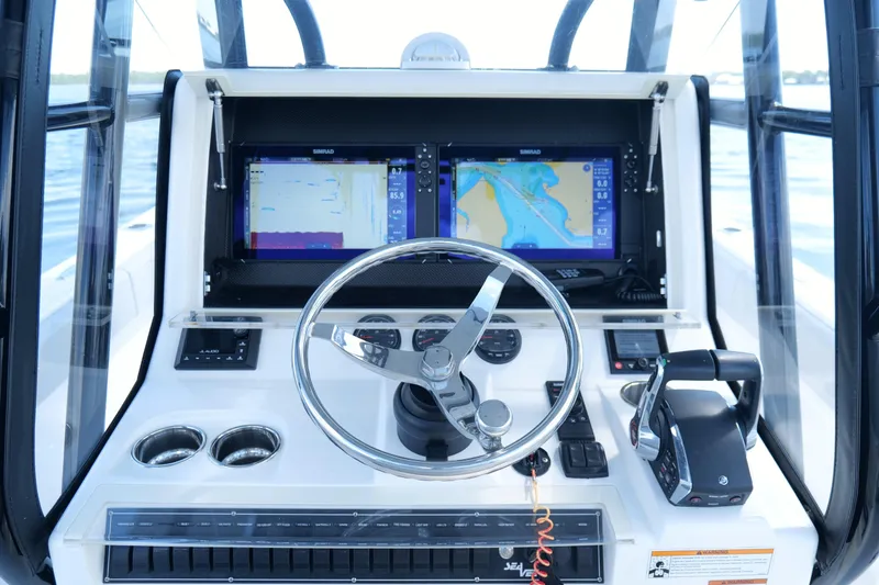  Yacht Photos Pics 2023 SeaVee 32 boat dashboard with dual navigation screens and steering wheel.
