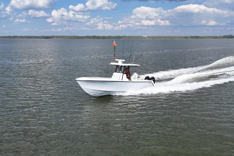  Yacht Photos Pics 2023 SeaVee 32 boat cruising on open water under a partly cloudy sky.