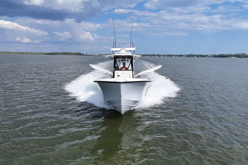  Yacht Photos Pics 2023 SeaVee 32 boat cruising on open water under a partly cloudy sky.