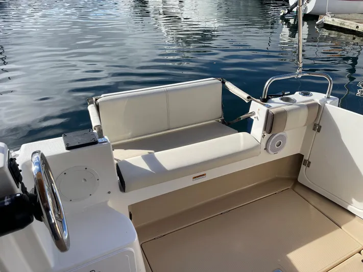  Yacht Photos Pics 2015 Cutwater 30 CB boat interior with seating and steering wheel, docked on calm water.