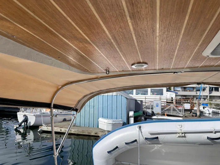  Yacht Photos Pics 2015 Cutwater 30 CB boat with wooden canopy, docked near blue shed.
