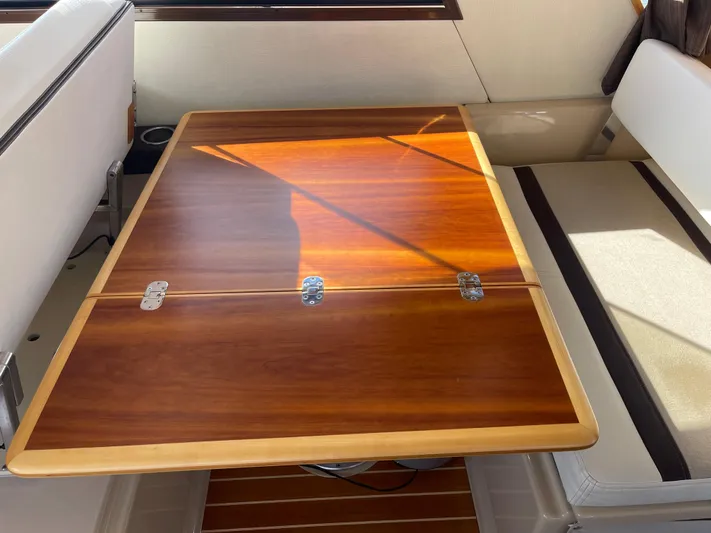  Yacht Photos Pics Interior of 2015 Cutwater 30 CB boat with wooden table and seating.