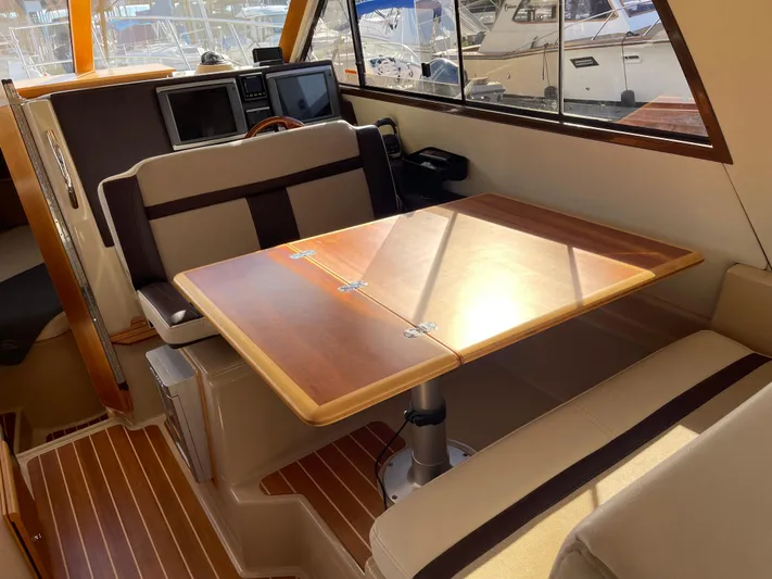  Yacht Photos Pics Interior of 2015 Cutwater 30 CB boat with wooden table and seating area.