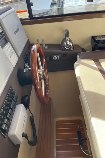  Yacht Photos Pics Interior helm of 2015 Cutwater 30 CB boat with wooden steering wheel and control panel.