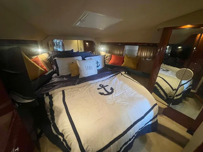 Andiamo II Yacht Photos Pics Luxurious bedroom interior of 2002 Sea Ray 480 Motor Yacht with nautical-themed bedding.