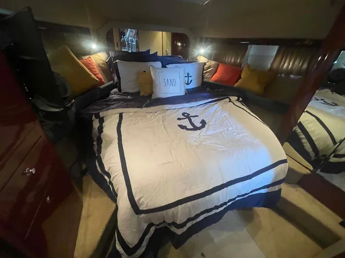 Andiamo II Yacht Photos Pics Luxurious bedroom interior of 2002 Sea Ray 480 Motor Yacht with nautical-themed bedding.