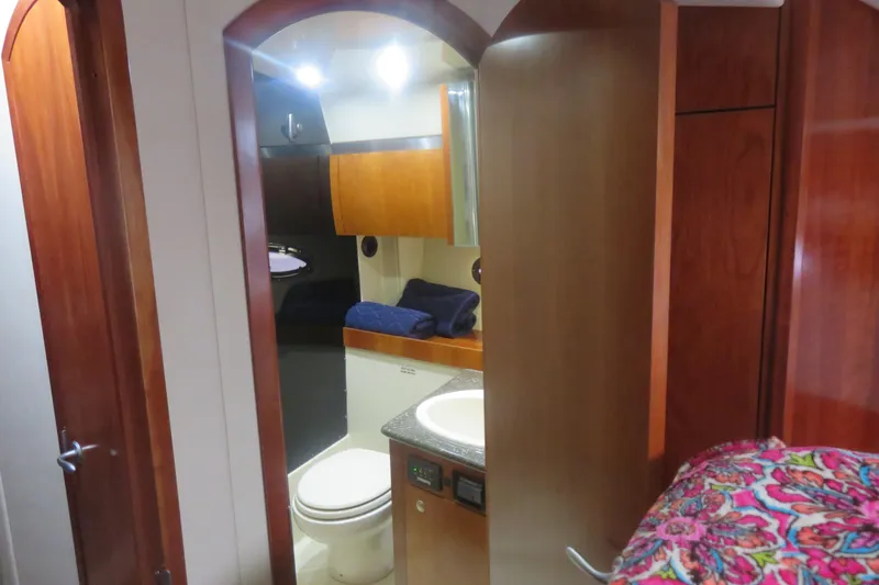 Swept Away Yacht Photos Pics 2007 Cruisers Yachts 420 Express interior bathroom with wooden cabinetry and modern fixtures.