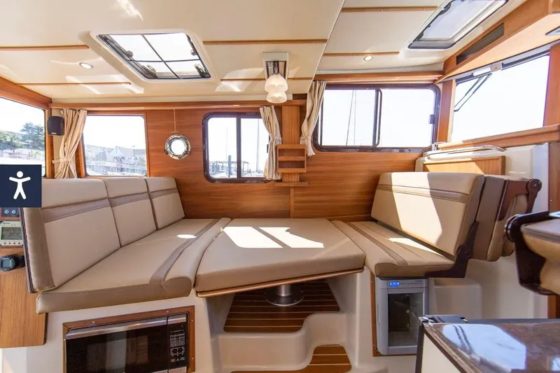 Maquinna Yacht Photos Pics 2024 Ranger Tugs R-31 CB interior with beige seating and wood accents.