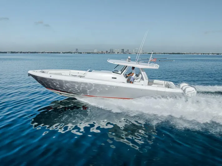  Yacht Photos Pics 2019 Intrepid 407 Panacea cruising on calm blue waters near a city skyline.