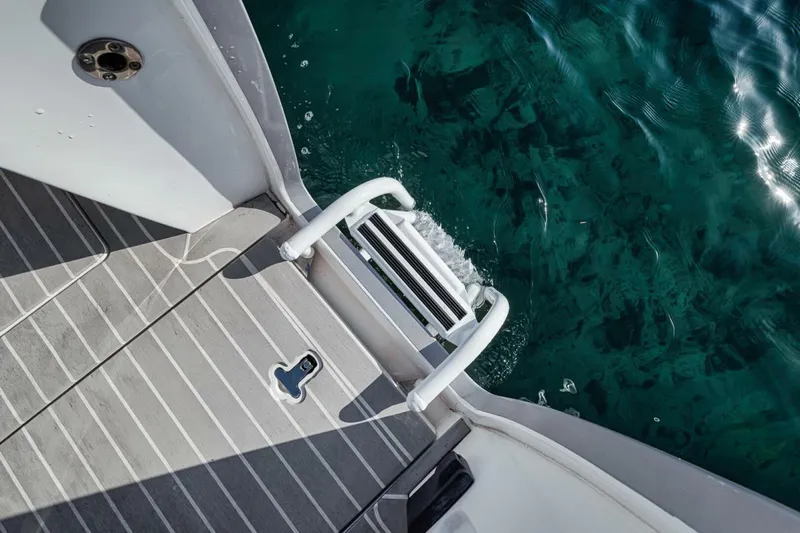  Yacht Photos Pics 2019 Intrepid 407 Panacea boat ladder and deck over clear blue water.