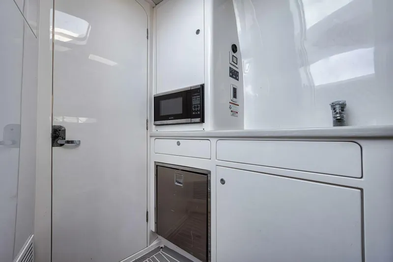  Yacht Photos Pics 2019 Intrepid 407 Panacea interior with modern kitchenette, featuring microwave and sleek cabinetry.