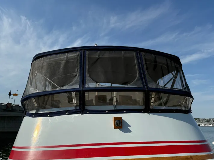 Aja Marie Yacht Photos Pics 1986 Marine Trader Tri Cabin boat with enclosed cockpit, docked under a clear blue sky.