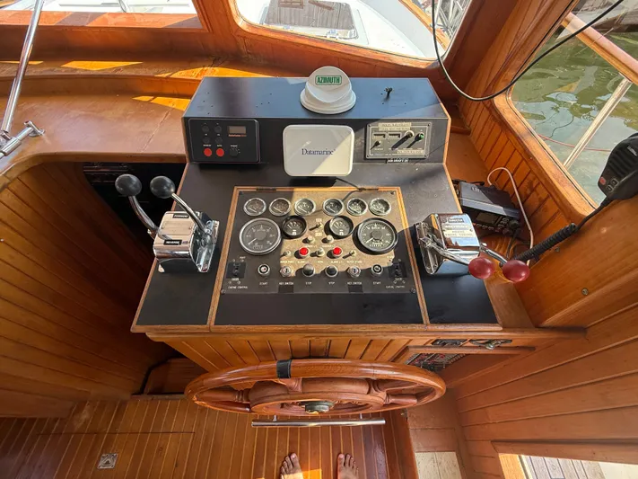 Aja Marie Yacht Photos Pics 1986 Marine Trader Tri Cabin helm with gauges, controls, and wooden steering wheel.