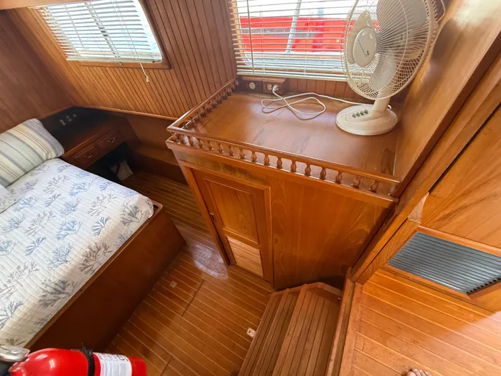 Aja Marie Yacht Photos Pics 1986 Marine Trader Tri Cabin interior with wooden finish, bed, fan, and fire extinguisher.