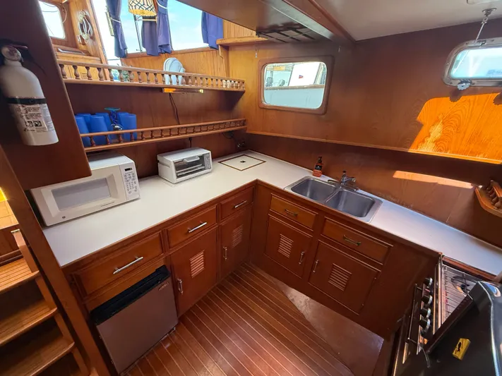 Aja Marie Yacht Photos Pics 1986 Marine Trader Tri Cabin kitchen with wooden cabinetry, microwave, toaster oven, and double sink.