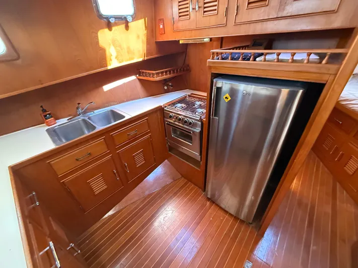 Aja Marie Yacht Photos Pics 1986 Marine Trader Tri Cabin kitchen with wood cabinetry, stainless steel appliances, and double sink.