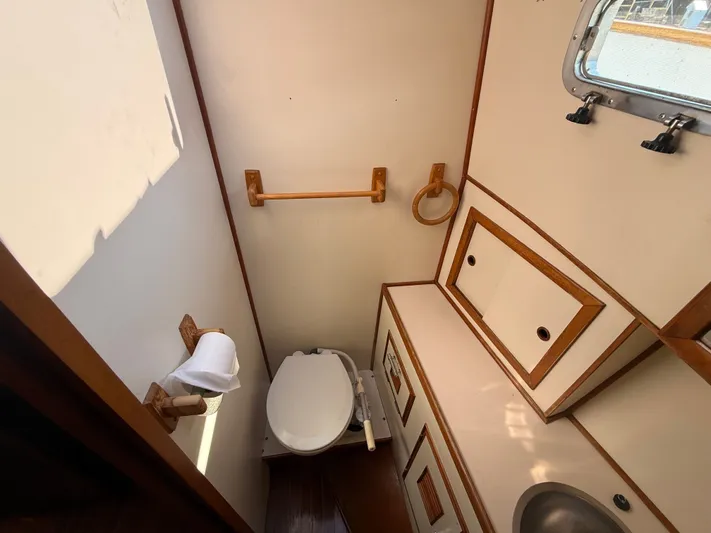 Aja Marie Yacht Photos Pics 1986 Marine Trader Tri Cabin bathroom with toilet, sink, and storage cabinets.