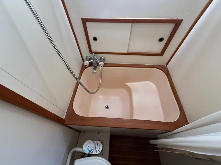 Aja Marie Yacht Photos Pics 1986 Marine Trader Tri Cabin bathroom with compact bathtub and showerhead.