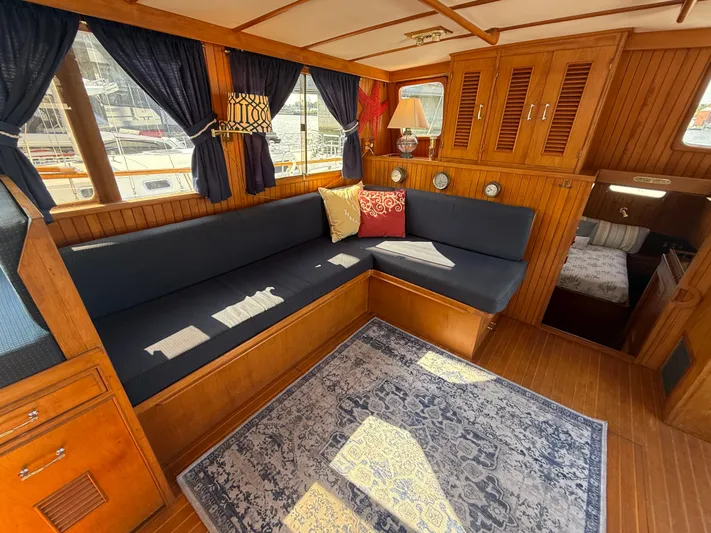 Aja Marie Yacht Photos Pics 1986 Marine Trader Tri Cabin interior with cozy seating, wooden cabinetry, and nautical decor.